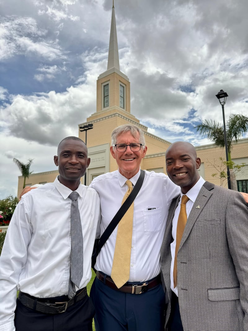Três homens estão do lado de fora do Templo de Harare, Zimbábue.