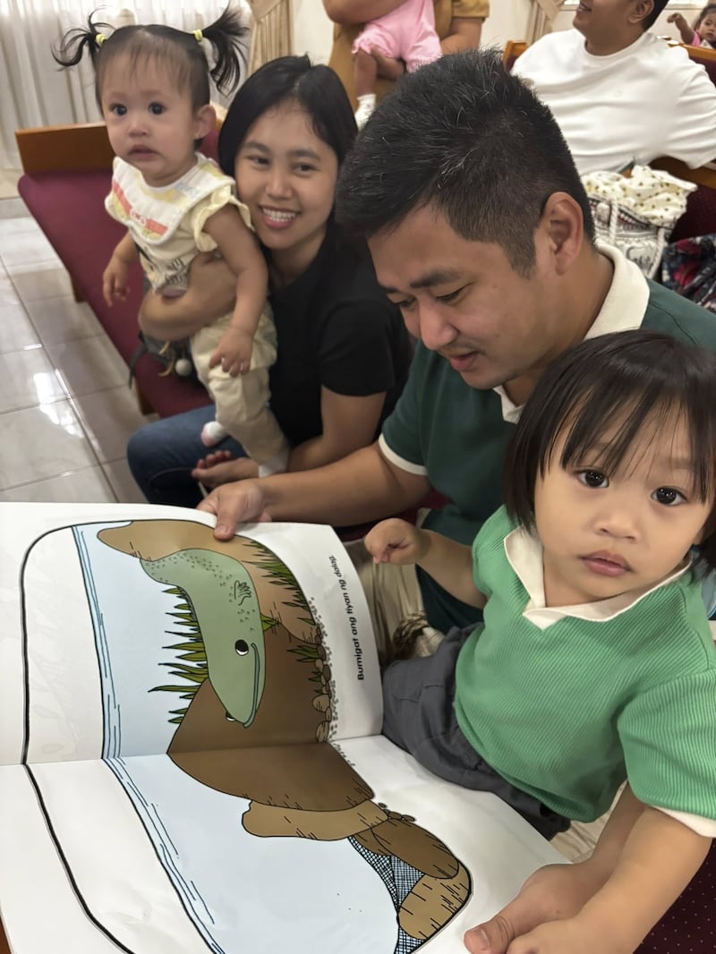 Uma família lê um livro sobre nutrição durante a primeira triagem do Programa de Nutrição Infantil realizada no Centro de Estaca Caloocan Filipinas em 24 de janeiro de 2026.