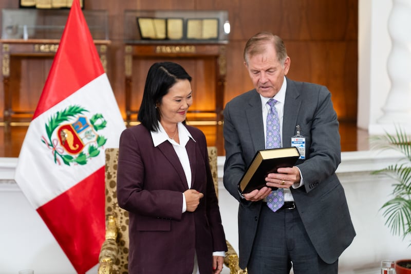 Élder Gary E. Stevenson do Quórum dos Doze Apóstolos de A Igreja de Jesus Cristo dos Santos dos Últimos Dias presenteia a presidente peruana Keiko Fujimori Higuchi com uma cópia do Livro de Mórmon, como parte de um ministério no país sul-americano na quinta-feira, 27 de agosto de 2026, no Palácio do Governo em Lima, Peru.