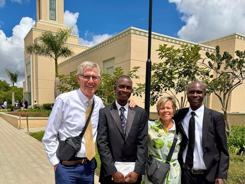 Kilford Shereni e Reginald Magocha posam para uma foto com Bruce e Elizabeth Anderson fora do Templo de Harare, Zimbábue.