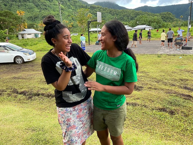 À direita, Brenda Fagaote e Maryanne Ahsee riem enquanto participam de uma conferência de jovens em Sauniatu, Samoa, em abril de 2023.