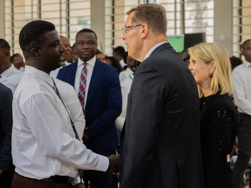 Élder Clark G. Gilbert do Quórum dos Doze Apóstolos, ao centro, e sua esposa, Irmã Christine Gilbert, à direita, cumprimentam os alunos de BYU–Pathway após o devocional em Accra, Gana, na sexta-feira, 28 de agosto de 2026.
