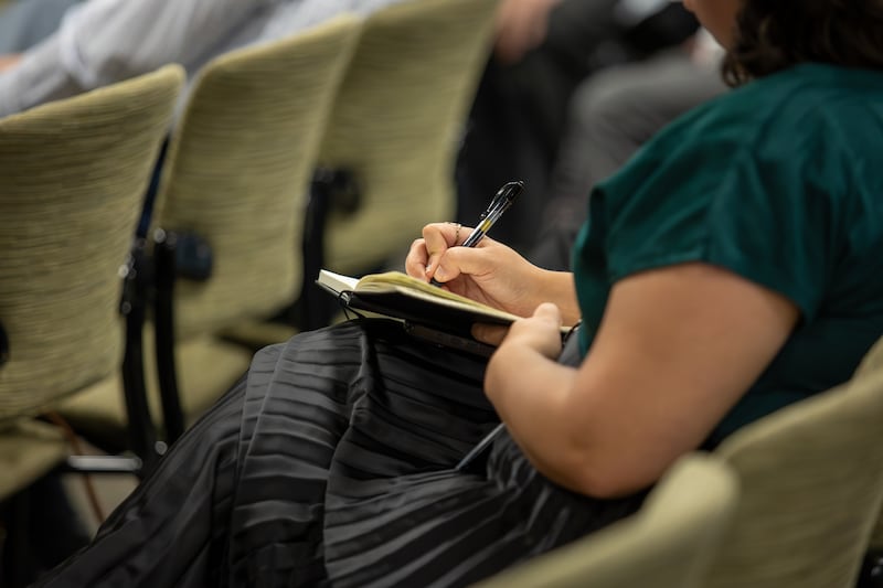 Uma estudante da Ensign College tira notas durante o devocional de campus em Salt Lake City em 22 de setembro de 2026.