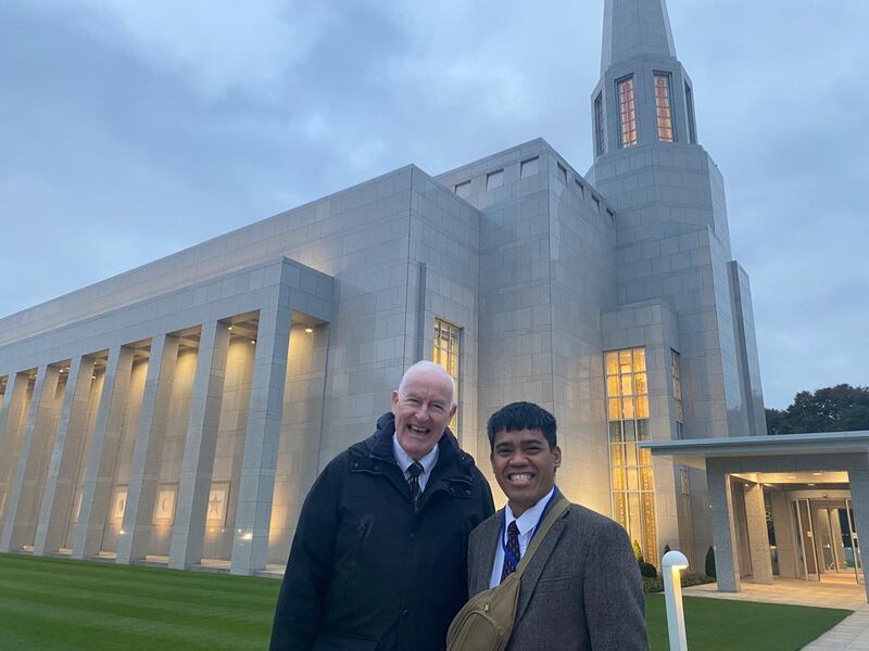 Sigfred Ducusin e Joe Tiernan sorriem em frente ao Templo de Preston, Inglaterra, após viajar longas horas para fazer o trabalho de templo de 14 a 17 de outubro de 2025.