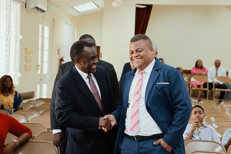 Élder Edward Dube da Presidência dos Setenta aperta a mão com um membro em uma conferência especial em Puerto Plata, República Dominicana, em 13 de setembro de 2026.