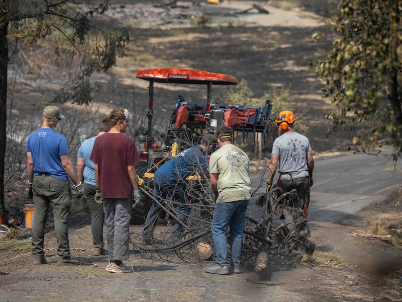 Rapazes jovens e líderes da Estaca Mount Spokane de Spokane, Washington ajudam a limpar os escombros de um bairro danificado por incêndios florestais em Spokane, Washington, na segunda-feira, 3 de agosto de 2026.