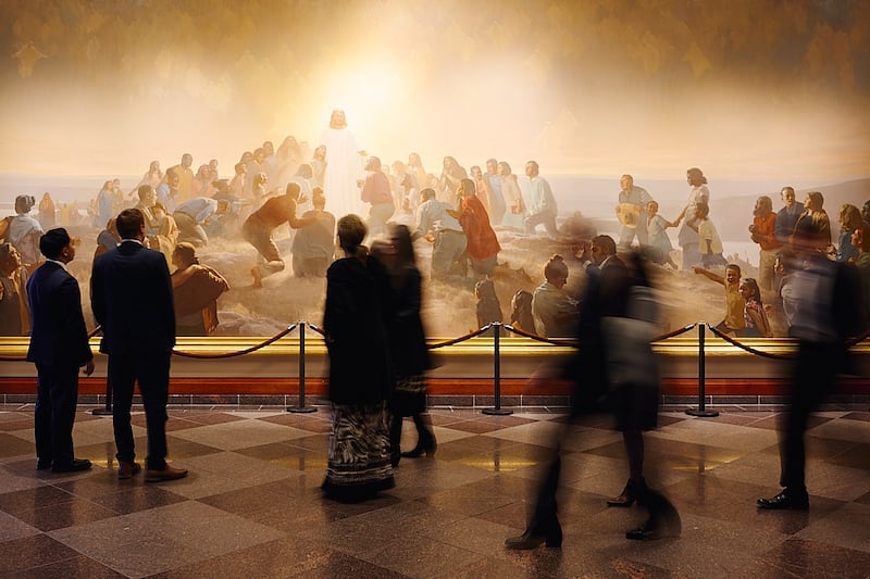 Pessoas passam por uma pintura do Salvador no Centro de Conferências de Salt Lake City antes da sessão da manhã de domingo da conferência geral de outubro de 2025 no domingo, 5 de outubro de 2025.