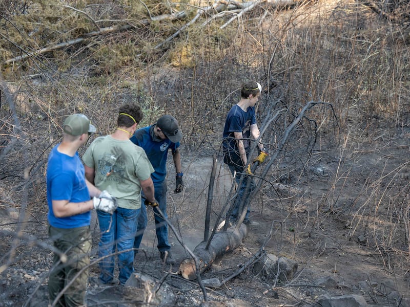 Jovens homens e líderes da Estaca Mount Spokane de Spokane, Washington ajudam a limpar os escombros de um bairro danificado por incêndios florestais em Spokane, Washington, na segunda-feira, 3 de agosto de 2026.