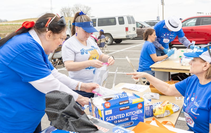 Pessoas participam de um projeto de serviço antes da noite JustServe no jogo do Kansas City Royals em Kansas City, Missouri, quinta-feira, 9 de abril de 2026.