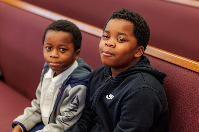Dois meninos aguardam o início das reuniões da igreja do novo Ala Treasure Valley (Swahili) de Boise, Idaho, no domingo, 8 de fevereiro de 2026.