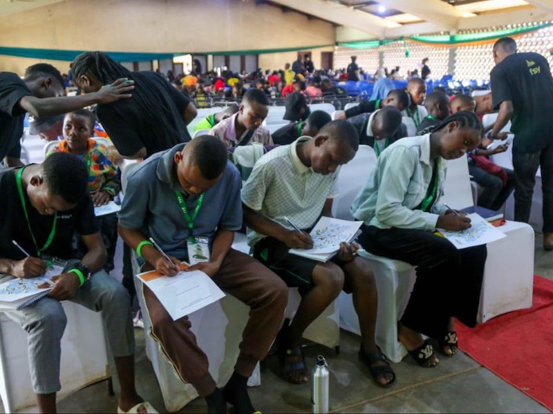 Jovens preenchem suas informações da história da família, durante a conferência FSY em Korogwe, Tanzânia, realizada de 26 a 30 de junho de 2023.