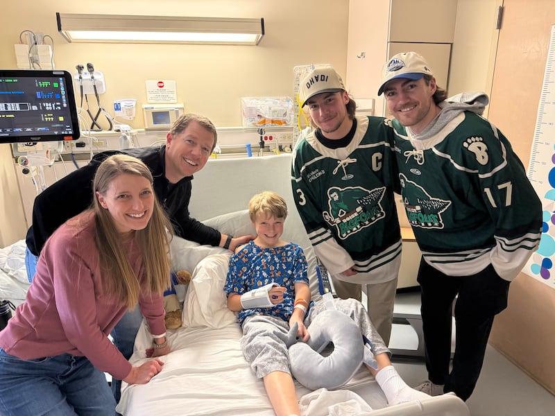 Nate Cooper, de 9 anos, ao centro, filho de Allie e Lee Cooper, à esquerda, recebe a visita dos jogadores de hóquei do Idaho Steelheads Nick Canade e Ty Pelton-Byce, do time de hóquei Idaho Steelheads, no St. Luke's Children's Hospital em Boise, Idaho, em 10 de março de 2026.