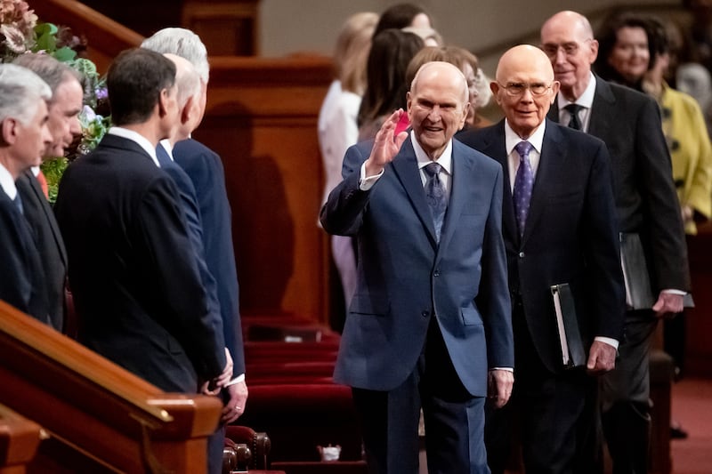 Presidente Russell M. Nelson, de A Igreja de Jesus Cristo dos Santos dos Últimos Dias, ao centro, e seus conselheiros, Presidente Dallin H. Oaks, primeiro conselheiro na Primeira Presidência, à direita, seguido logo atrás por Presidente Henry B. Eyring, segundo conselheiro na Primeira Presidência, chegam para a Sessão das Mulheres da 192ª conferência geral anual, no Centro de Conferências em Salt Lake City no sábado, 2 de abril de 2022.