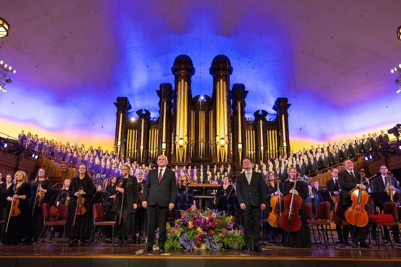 O Coro do Tabernáculo e a Orquestra da Praça do Templo levantam-se para os aplausos durante uma apresentação de 2025 de "Música e Palavras de Inspiração" no edifício histórico do Tabernáculo em Salt Lake City.