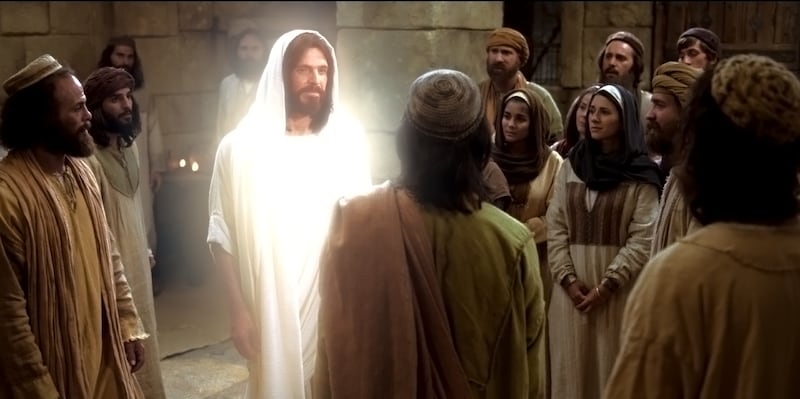 Jesus Cristo ressurreto se aproxima de seus apóstolos e outras pessoas nesta cena de um dos episódios de Vídeos da Bíblia.