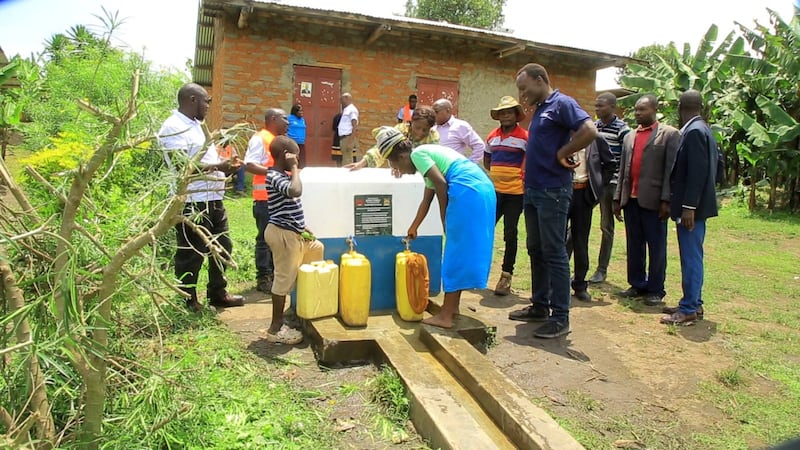 Líderes e membros da comunidade utilizam um ponto de água recém-construído no distrito de Kabarole, Uganda, em 30 de setembro de 2025.