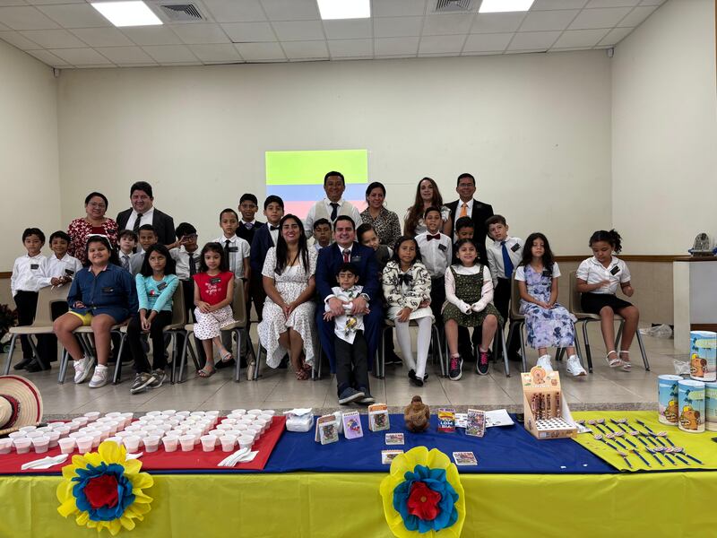 Crianças da Primária e líderes da Estaca Samborondón Equador posam para uma foto com a bandeira da Colômbia durante a atividade do centro de treinamento missionário mini da estaca em Guayaquil, Equador, 21 de fevereiro de 2026.