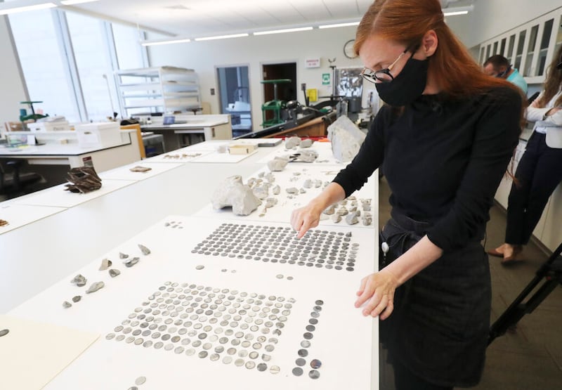 Emiline Twitchell, conservadora da Biblioteca de História da Igreja, observa as moedas encontradas na pedra circular do Templo de Salt Lake City e na cápsula do tempo em Salt Lake City na terça-feira, dia 14 de julho de 2020.