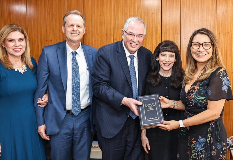 Élder Neil L. Andersen, do Quórum dos Doze Apóstolos, ao centro, e a irmã Kathy Andersen posam para uma foto com a primeira-dama do Brasil, Rosângela Lula da Silva, à direita, mostrando a cópia do Livro de Mórmon que lhe foi dada, durante uma reunião no Palácio do Planalto em Brasília na segunda-feira, 6 de março de 2023. À esquerda, irmã Michele Koch e Élder Joni L. Koch.