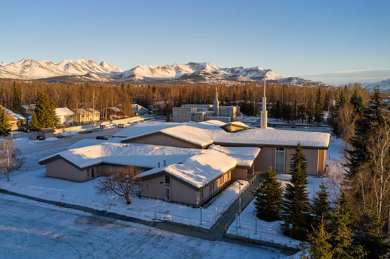 O Centro de Estaca de Anchorage, Alasca é mostrado em primeiro plano, com o Templo de Anchorage, Alasca ao fundo.