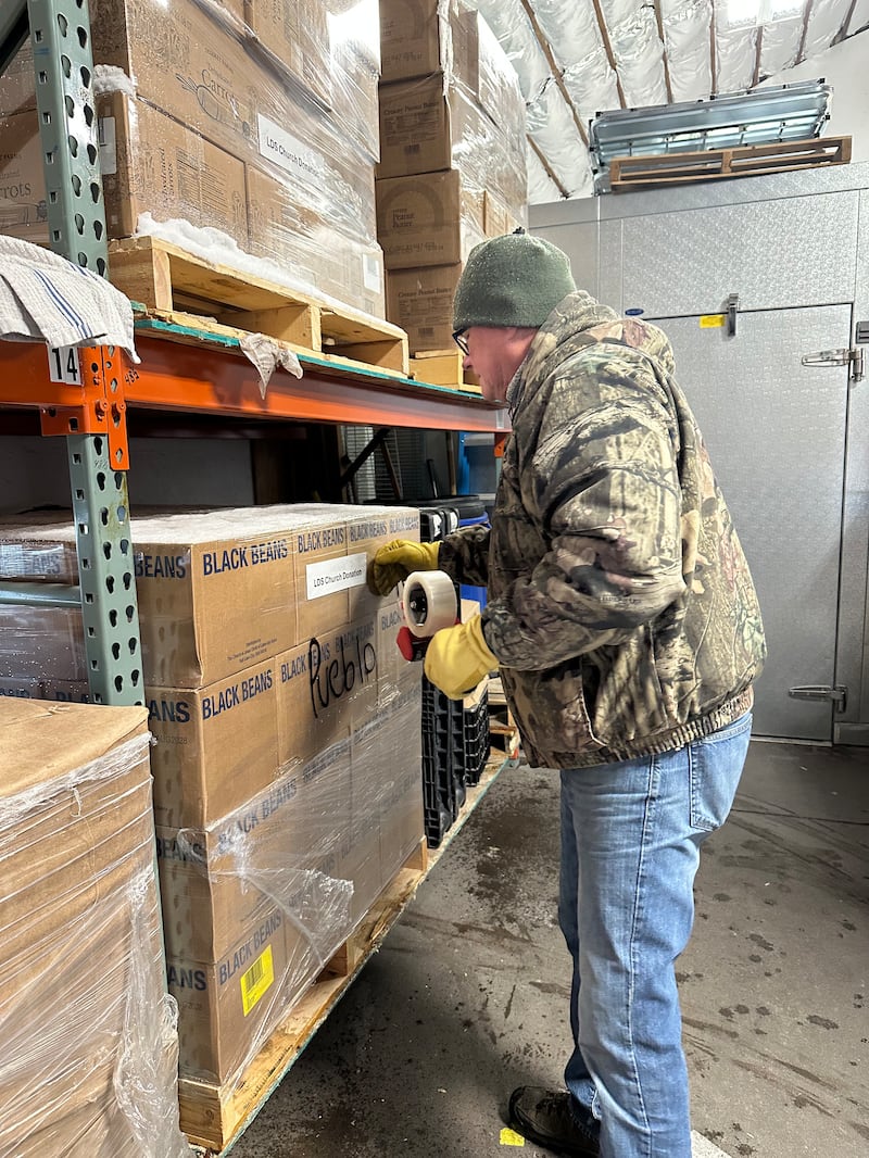 O voluntário do Pueblo Cooperative Care, Denton Jorgensen, rotula um palete de feijões pretos doados pela Igreja de Jesus Cristo dos Santos dos Últimos Dias no depósito do Pueblo Cooperative Care em Pueblo, Colorado, 3 de dezembro de 2025.