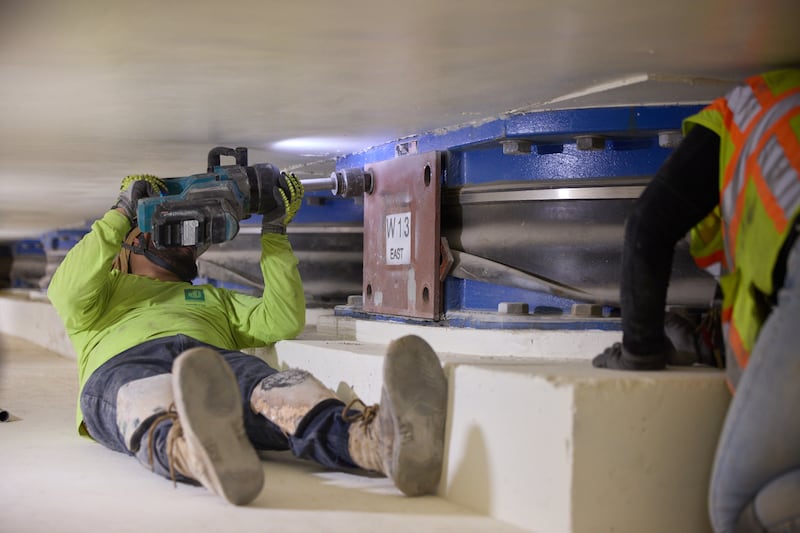 Equipes removem parafusos de um dos 98 isoladores de base localizados 20 pés abaixo do Templo de Salt Lake em Salt Lake City na quinta-feira, 25 de junho de 2026.
