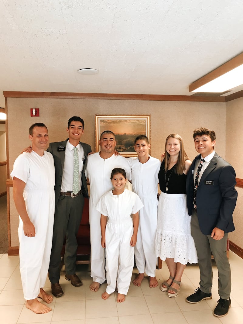 Daniel, Alex e Rose Mendez estão vestindo macacões brancos de batismo com os missionários após seus batismos de Pensacola, Flórida, em junho de 2022.