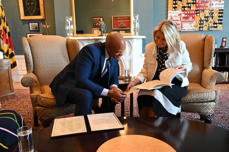 A Presidente Camille N. Johnson e o Governador de Maryland Wes Moore analisam a história da família dele no escritório em Annapolis, Maryland, na sexta-feira, 15 de maio de 2026.