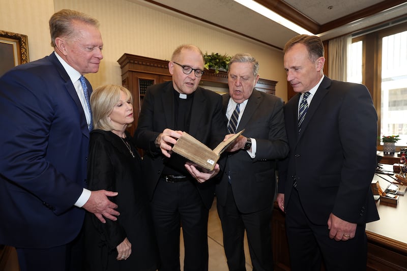 Dave e Deb Checketts, Reverendo Dr. Andrew Teal, Élder Jeffrey R. Holland e Élder Kyle McKay conversam ao se encontrarem no escritório de Élder Holland, no Edifício de Administração da Igreja em Salt Lake City na quarta-feira, 5 de outubro de 2022. O Reverendo Teal presenteia a Igreja com “uma Bíblia da Restauração de Carlos II” de seu reinado, após o fracassado projeto da República da Inglaterra e a Guerra Civil Inglesa.