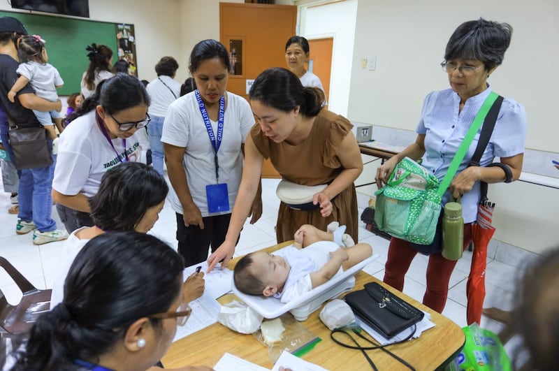 Uma criança é pesada durante uma triagem de saúde e nutrição em Tacloban City, Filipinas, 19 de setembro de 2026.