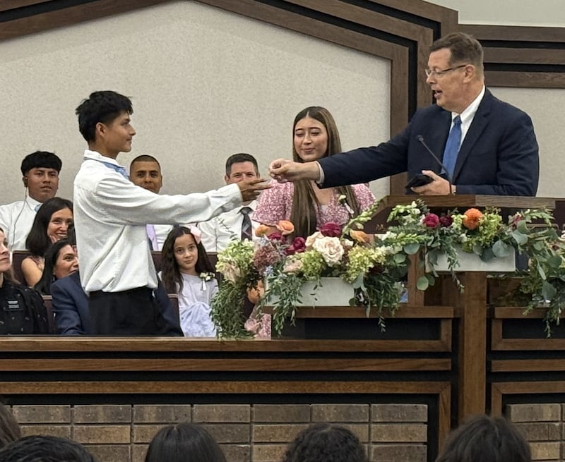 Élder Clark G. Gilbert do Quórum dos Doze Apóstolos entrega a Jose Coy, 18 anos, um cartão com seu endereço de e-mail no Centro de Estaca de Schaumburg Illinois em Chicago, Illinois no domingo, 20 de setembro de 2026.