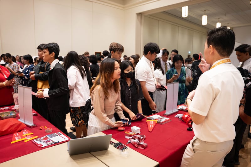 Os participantes visitam o estande da BYU–Hawaii na feira de educação da Área da Ásia em Bangkok, Tailândia, 19 de outubro de 2025.