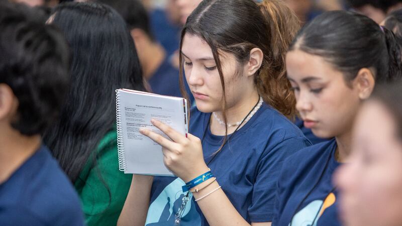Uma jovem toma notas durante uma sessão das conferências de Para o Vigor da Juventude na Área América do Sul Sul no início de 2026.