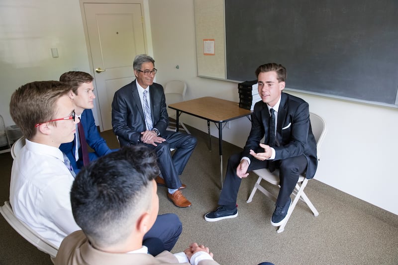 Jovens têm uma discussão durante uma reunião de quórum no Dia do Senhor.
