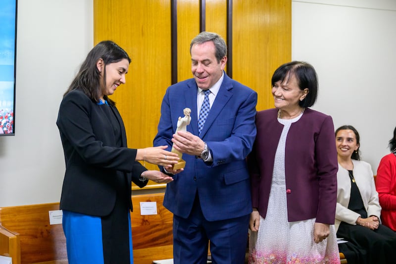 Elder Eduardo Gavarret e irmã Norma Gavarret entregam um prêmio a Judith Marín durante a cerimônia "Women who Illuminate" em Santiago, Chile, março de 2026.
