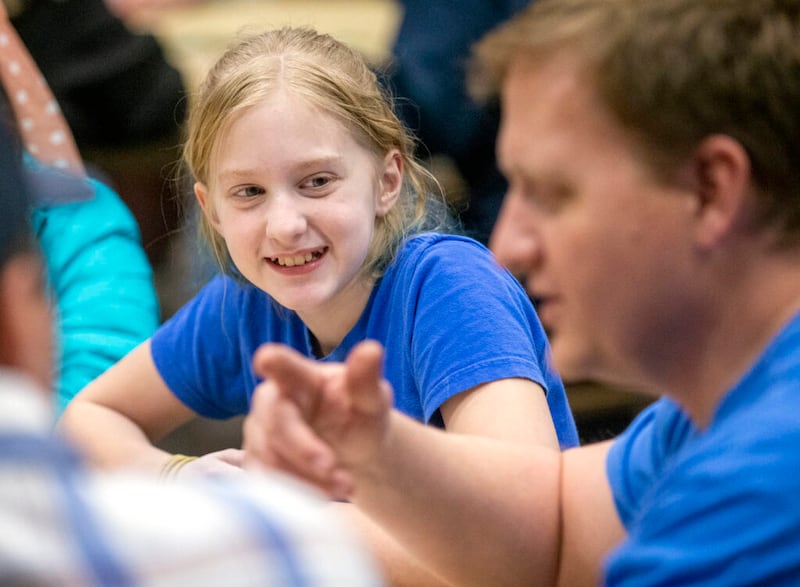 Gwen Buehner sorri para Dave Hansen, um especialista do quórum de sacerdotes, enquanto ele fala, ao passo que jovens e líderes da ala Willow Creek 6, estaca Sandy Utah Willow Creek de A Igreja de Jesus Cristo dos Santos dos Últimos Dias, se reúnem para jogar na quarta-feira, dia 22 de janeiro, 2020.