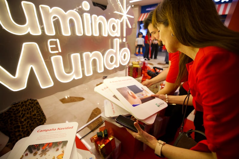 Voluntários nas Giving Machines em Buenos Aires, Argentina, examinam os cartões que as pessoas podem escolher para doar itens e serviços, no dia da inauguração das máquinas na Argentina em 30 de novembro de 2025.
