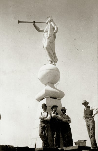 Trabalhadores que concluíram o Templo de Salt Lake, em 1893, posam para uma foto na torre abaixo da estátua do Anjo Morôni, de Cyrus Dallin.