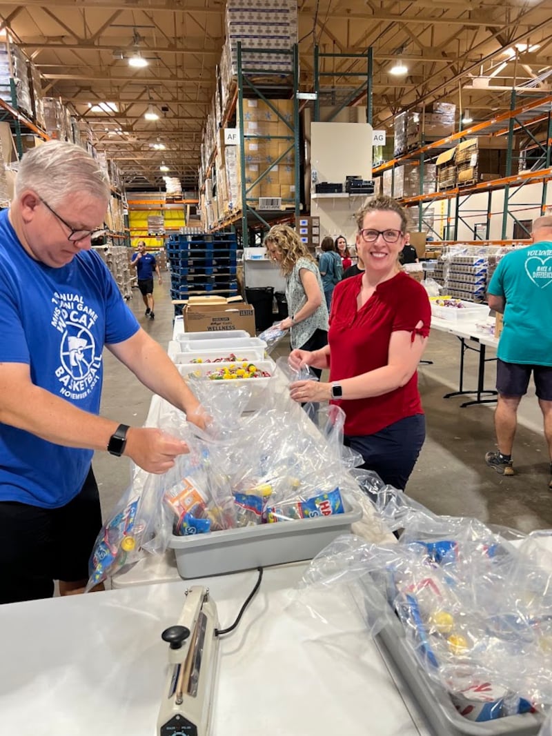 Amigos e membros da família de Gwynne Fullmer fazem pacotes de lanches no Midwest Food Bank em Gilbert, Arizona, em 18 de outubro de 2025, para celebrar o 70º aniversário de Fullmer.