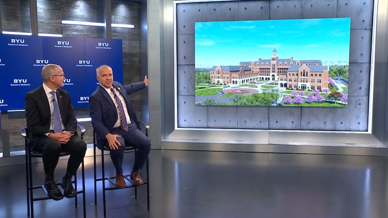 O Presidente da Brigham Young University C. Shane Reese exibe uma ilustração do exterior da nova Escola de Medicina da BYU ao lado do Dr. Mark J. Ott, diretor da escola, em um anúncio em Provo, Utah, quarta-feira, 14 de outubro de 2026.