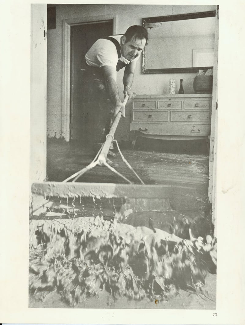 O residente de Rexburg, Idaho, Garrett Case varre lama de sua casa após o rompimento da Barragem Teton em junho de 1976.