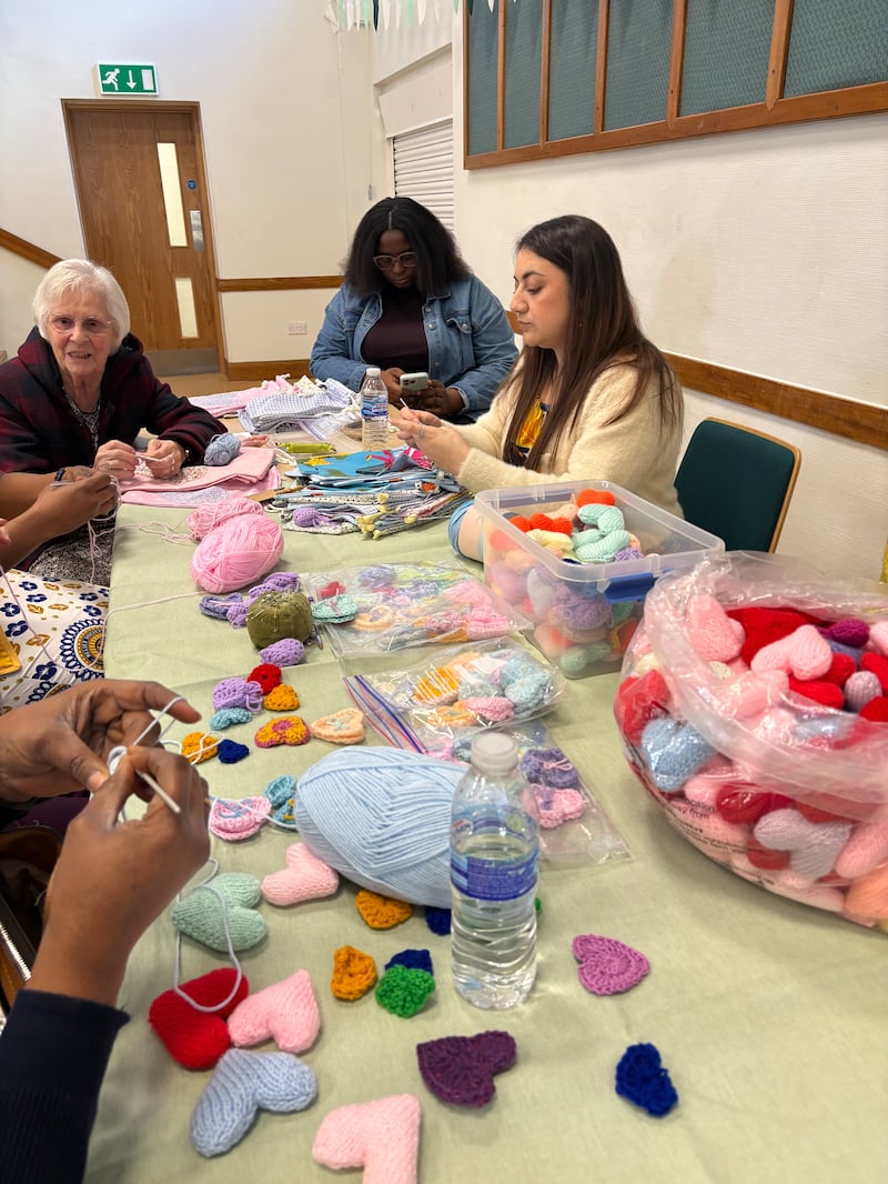 A Sociedade de Socorro do Bairro Milton Keynes faz corações de tricô para a unidade neonatal do hospital de Milton Keynes durante um dia de serviço em Northampton, Inglaterra, 14 de março de 2026.