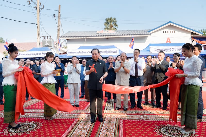 Espectadores aplaudem enquanto Chheang Ra, ministro da saúde do Reino do Camboja, corta a fita para comemorar a inauguração do novo edifício ambulatorial no Hospital de Referência Preah Net Preah na província de Banteay Meanchey, no noroeste do Camboja, em 26 de fevereiro de 2026.