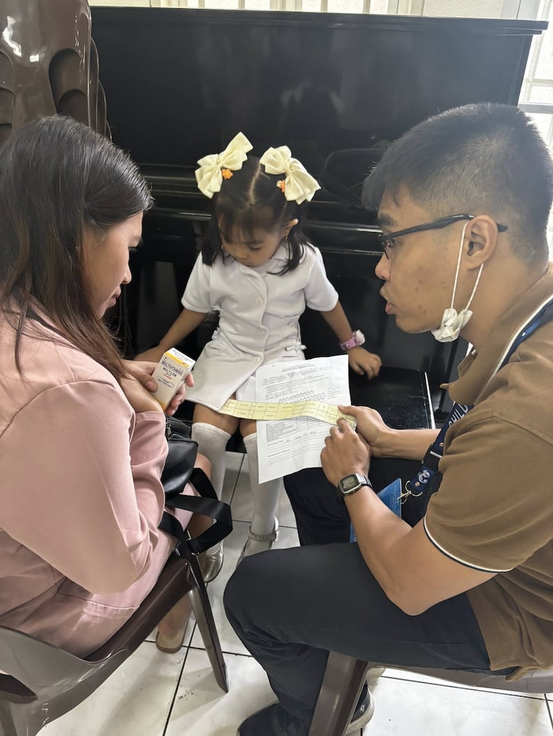 Um profissional de saúde conversa com uma mãe sobre o crescimento de sua filha durante uma triagem do Programa de Nutrição Infantil realizada no Centro de Estaca Caloocan Filipinas em 24 de janeiro de 2026.