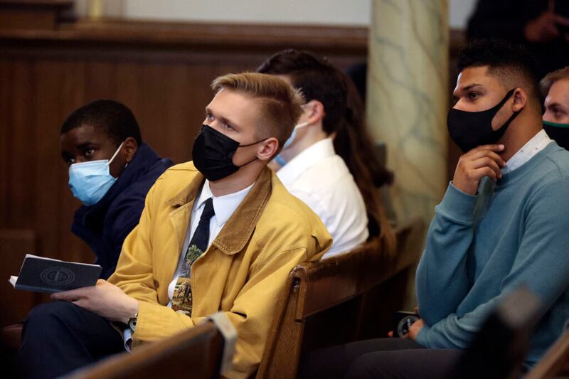 Uyiosa Iduma, Jacob Hatch e Raskita Taylor, alunos da Ensign College, ouvem Élder Ronald A. Rasband, do Quórum dos Doze Apóstolos, discursar durante um devocional no Assembly Hall em Salt Lake City na terça-feira, 26 de outubro de 2021.