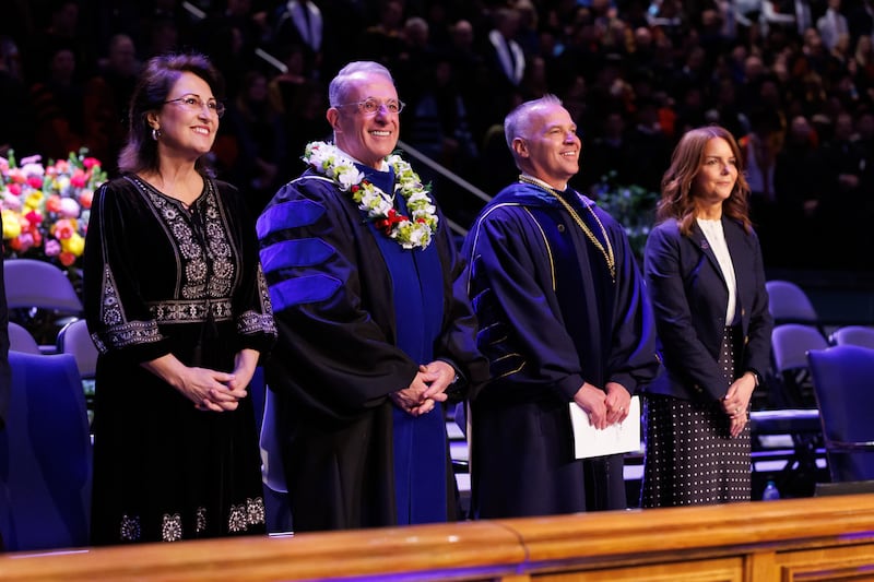 Élder Ulisses Soares do Quórum dos Doze Apóstolos e sua esposa, Irmã Rosana Soares, à esquerda, e o Presidente de BYU C. Shane Reese e sua esposa, Irmã Wendy Reese, à direita, participam da cerimônia de formatura na quinta-feira, 23 de abril de 2026, no Marriott Center em Provo, Utah.