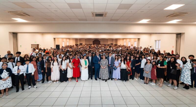 Elder Taylor G. Godoy — Setenta Autoridade Geral e primeiro conselheiro da presidência da Área Noroeste da América do Sul — e Sister Carol Godoy tiram uma foto em grupo com os jovens, pais e líderes presentes durante o devocional de Lima, Peru, em 11 de janeiro de 2026.