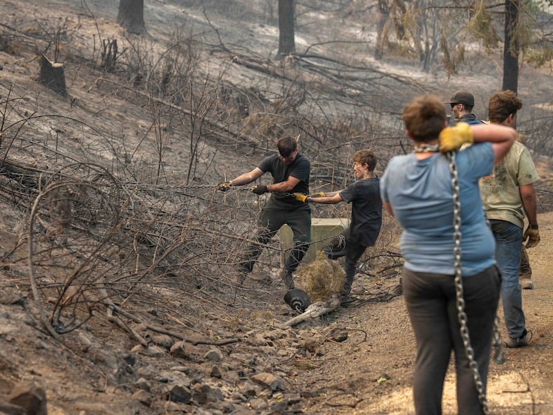 Rapazes e líderes do Stake Monte Spokane de Spokane, Washington ajudam a limpar escombros de um bairro danificado por incêndios florestais em Spokane, Washington, na segunda-feira, 3 de agosto de 2026.
