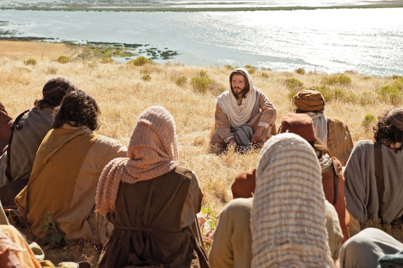 O Salvador, Jesus Cristo, está sendo retratado ensinando o Sermão da Montanha em um Vídeo da Bíblia.
