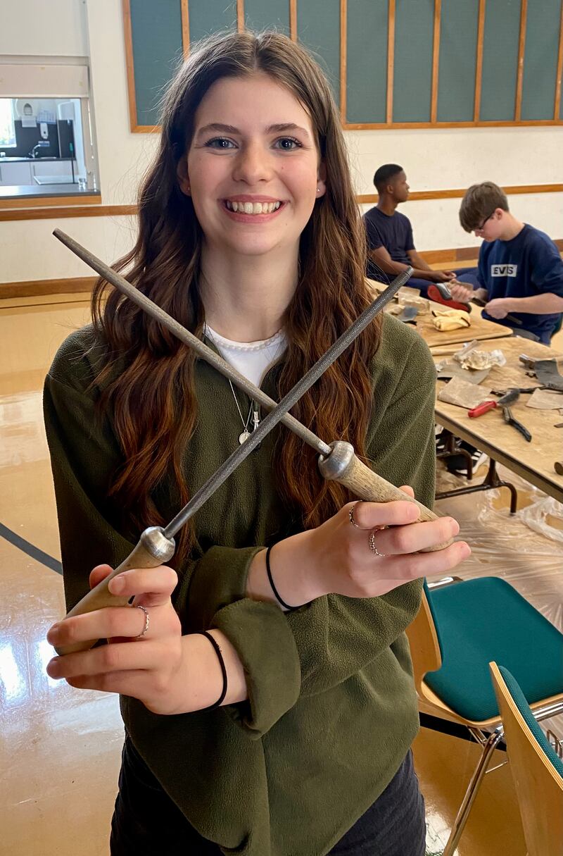 Uma jovem da Estaca Northampton Inglaterra mostra ferramentas antigas sendo recuperadas para serem doadas à organização chamada Tools with a Mission em abril de 2024.